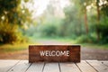 Wooden welcome sign on green forest natural background with copy space. AI generated