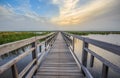 Wooden wetland walkway with sunset sky