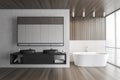 Wooden and white bathroom with bathtub and two sinks, parquet floor Royalty Free Stock Photo