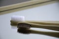 Wooden white and brown toothbrushes on mirror.