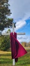 Wooden white cross with red cloth blowing in the wind front of beautiful countryside view and blue sky Royalty Free Stock Photo