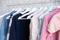 Wooden white hangers with clothes on the rail in the store with women's clothing Royalty Free Stock Photo