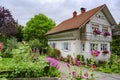 Wooden white house in Alps with beautiful flowering summer garden Royalty Free Stock Photo