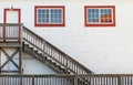 Wooden white house entrance with red windows and door with rustic wooden staircase in British Columbia Royalty Free Stock Photo