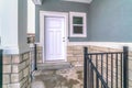 Wooden white panelled hinged front door and small sliding window at home facade