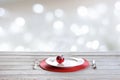 Wooden white tabletop with christmas place setting, red decor on abstract white bokeh. Christmas mock up. Royalty Free Stock Photo