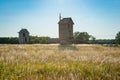 Wooden windmill on background field and sky.