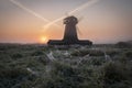 Wooden windmill in the countryside at dawn in autumn, in the morning of the first frost and frost on the web Royalty Free Stock Photo