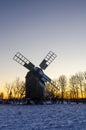 Wooden windmill by sunset in winter time Royalty Free Stock Photo