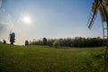 Wooden windmills in the middle of the field against the background of the Lem and the sky with the sun.