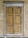 Wooden window with closed shutters on the facade of an old brick building Royalty Free Stock Photo