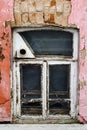 Wooden window with a hole for a samovar pipe, in the wall of the basement of an old house Royalty Free Stock Photo