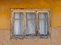 Wooden window of a house with old adobe walls. A wooden window with a white curtain. Exterior view Royalty Free Stock Photo