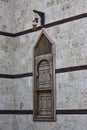 Wooden window of a mosque with an antique lamp hanging on top in the city of Yambu