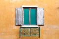 Wooden window on saturate yellow wall house.