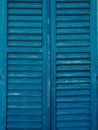 Wooden window shutters in blue. Antique homemade shutters on the