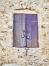 Wooden window on a stone wall with a Nazar boncugu, a Turkish am