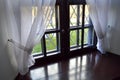 Wooden window with a wide window sill and white beautiful curtains, tulle Royalty Free Stock Photo