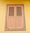 Wooden window on yellow cement wall