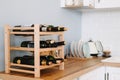 Wooden wine shelves with bottles on the table in modern kitchen Royalty Free Stock Photo