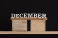 Wooden winter calendar months - December. Wooden letters. Black background