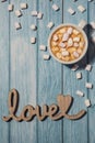 Wooden word love with heart romance with white coffee cup of hot chocolate and small marshmallows. Minimal Royalty Free Stock Photo