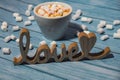 Wooden word love with heart romance with white coffee cup of hot chocolate and small marshmallows. Minimal Royalty Free Stock Photo