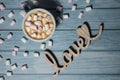 Wooden word love with heart romance with white coffee cup of hot chocolate and small marshmallows. Minimal Royalty Free Stock Photo
