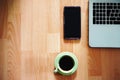 Wooden work table with copy space with laptop personal computer, mobile phone and cup of coffee