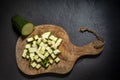 Wooden zucchini cubes, uncut piece of zucchini, elegant black kitchen background