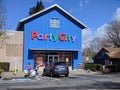 Woodinville, WA / USA - circa April 2021: Street view of a family leaving Party City with bags on a bright, sunny day