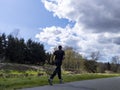 Woodinville, WA USA - circa April 2021: View of a man wearing all black clothing jogging on a walking and biking trail in