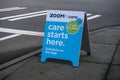 Woodinville, WA USA - circa February 2022: Angled view of a sandwich board on a sidewalk, advertising Zoom + Care just around the