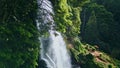 Woodland waterfall falling rocks closeup. Drone shot vivid water cascading mossy Royalty Free Stock Photo