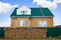 Woodpile with birch wood on the background of the house. Preparation of firewood for winter. Furnace heating Royalty Free Stock Photo