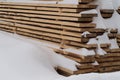 Woodpile stacked of firewood under the snow. Stack of cut wood under the snow Royalty Free Stock Photo