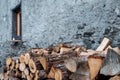 A woodpile, stored against an old, grey, weathered wall, outside a traditional alpine cottage Royalty Free Stock Photo