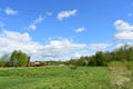 The woods Creek trail, the road. Village. Deciduous trees, young foliage and grass. Cloudy sky Royalty Free Stock Photo