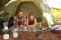 Into the woods. Shot of a young couple lying in a tent looking outwards.