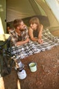 Into the woods. a young couple lying in a tent looking outwards.