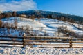 Woodshed on the hillside in winter mountains