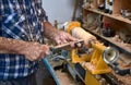 The woodturner work. Man`s arms with cutter in action. Royalty Free Stock Photo