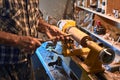 The woodturner work. Man`s arms with cutter in action. Royalty Free Stock Photo