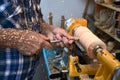 The woodturner work. Man`s arms with cutter in action. Royalty Free Stock Photo