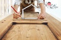 Woodwork concept, carpenter with the meter makes the shape of a