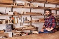 Woodwork craftsman in studio with shelves of wood pieces Royalty Free Stock Photo