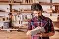 Woodwork designer using a digital tablet in his studio Royalty Free Stock Photo