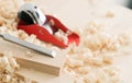 woodwork: a small red plane and chisel on the boards in shavings Royalty Free Stock Photo