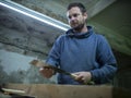 Woodworker with a beard sawing a wooden beam with a hand saw. a carpenter sawing a piece of wood Royalty Free Stock Photo