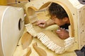 Woodworker Building Guitar in Workshop